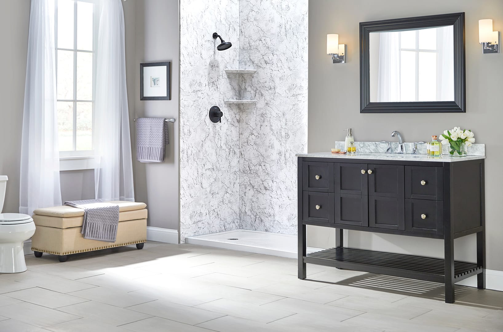 Walk-in shower with a matte black shower fixture and accessible design. Smooth, classy gray marble color walls.